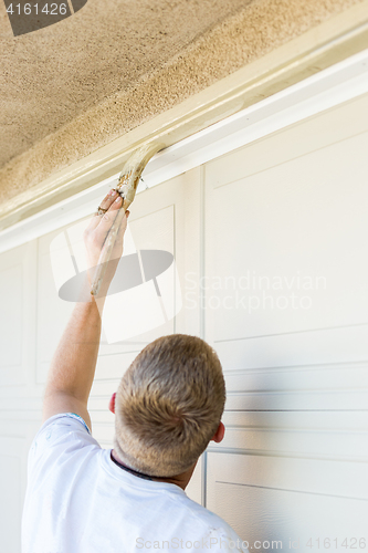 Image of Professional Painter Cutting In With Brush to Paint Garage Door 