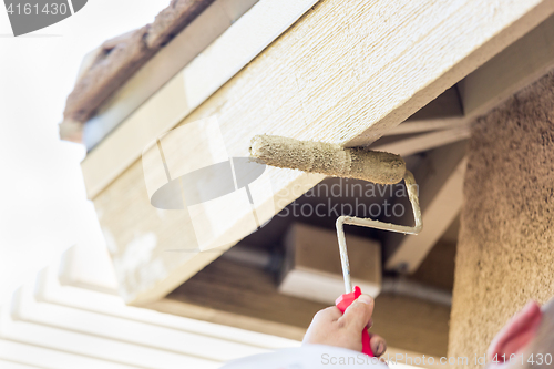 Image of Professional Painter Using Small Roller to Paint House Fascia