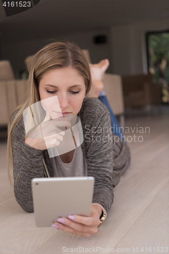 Image of young women used tablet computer on the floor