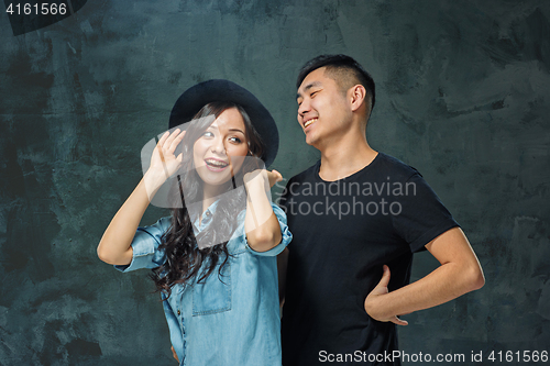 Image of Portrait of smiling Korean couple on a gray