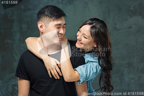 Image of Portrait of smiling Korean couple on a gray