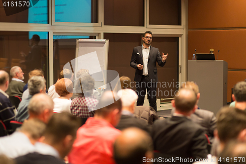 Image of Business speaker giving a talk in conference hall.