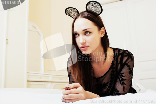 Image of young pretty brunette woman wearing sexy lace mouse ears, laying