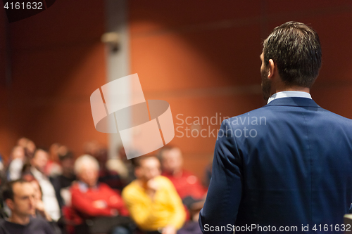 Image of Public speaker giving talk at Business Event.