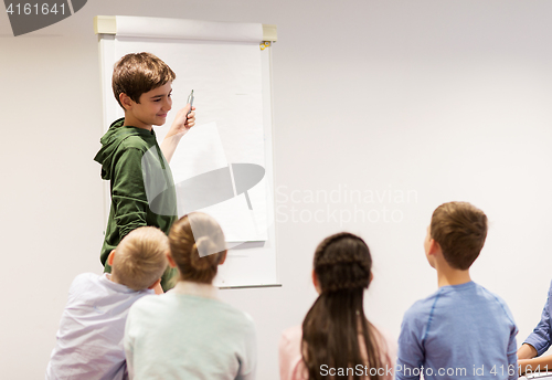 Image of student boy with marker writing on flip board