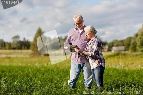 Image of happy senior couple with tablet pc at summer farm