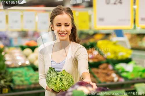 Image of happy woman buying savoy at grocery store