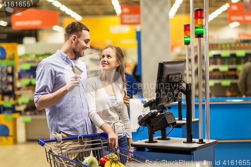 Image of couple buying food at grocery at cash register