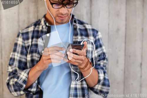 Image of man with earphones and smartphone listening music