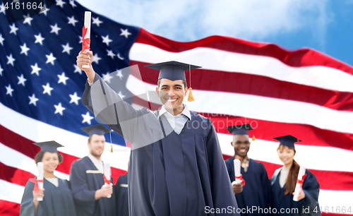 Image of happy students in mortarboards with diplomas