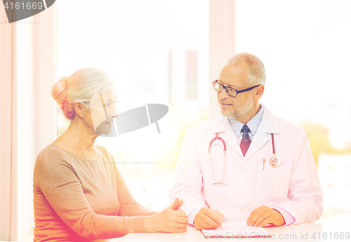 Image of smiling senior woman and doctor meeting