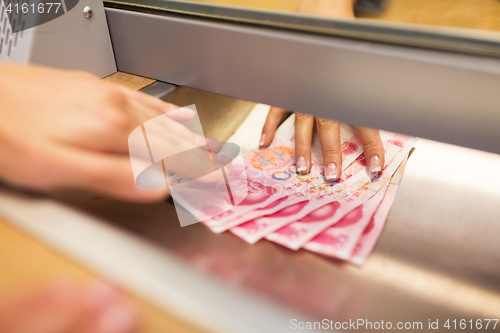 Image of clerk giving cash money to customer at bank office