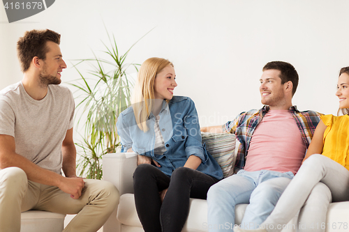 Image of group of happy friends talking at home