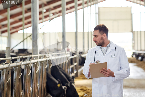 Image of veterinarian with cows in cowshed on dairy farm