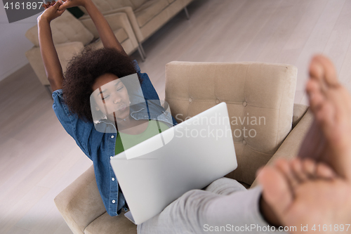 Image of African American women at home in the chair using a laptop