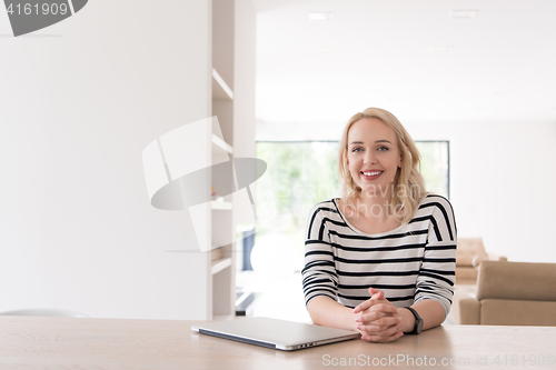 Image of Young woman with laptop at home