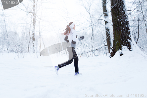 Image of Girl jogging in winter woods