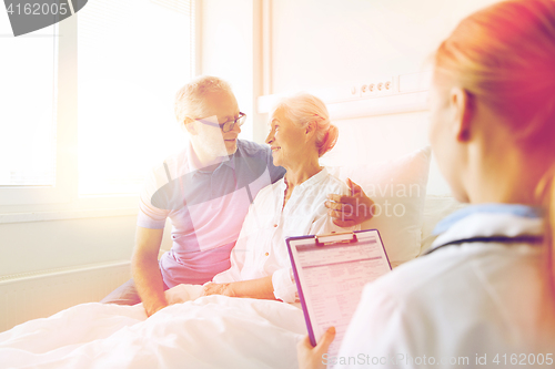 Image of senior woman and doctor with clipboard at hospital