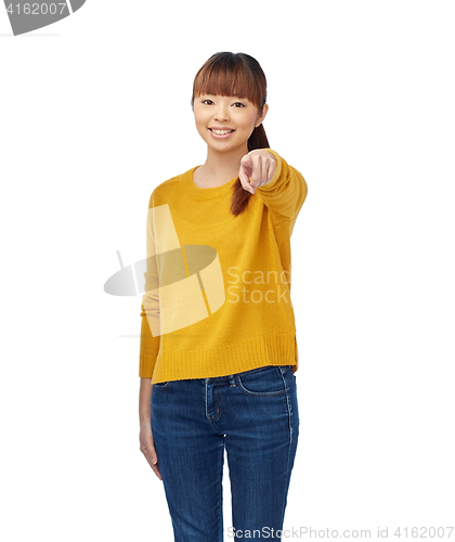 Image of happy asian young woman pointing finger on you