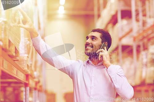 Image of happy man calling on smartphone at warehouse