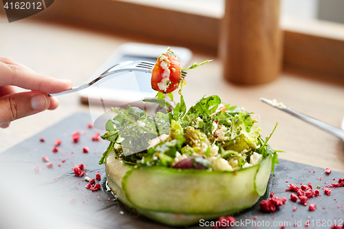 Image of woman eating cottage cheese salad at restaurant