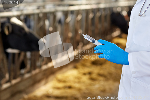 Image of veterinarian hand with vaccine in syringe on farm