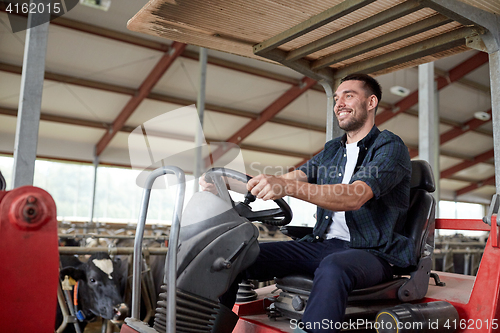 Image of man or farmer driving tractor at farm