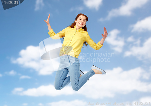 Image of smiling young woman jumping in air