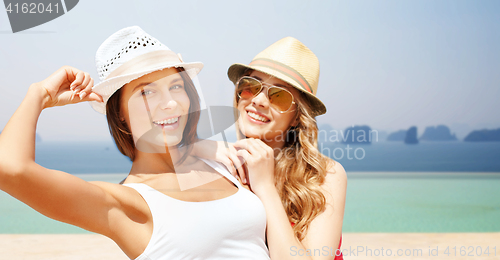 Image of happy young women in hats on summer beach