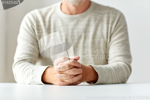 Image of close up of senior man hands on table