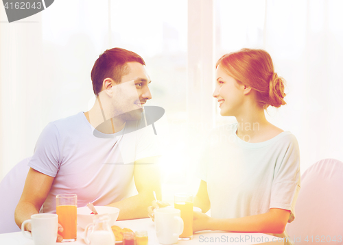 Image of smiling couple having breakfast at home