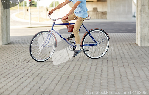 Image of hipster man riding fixed gear bike