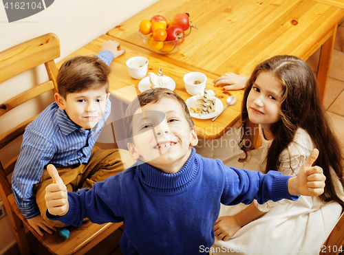 Image of little cute boys eating dessert on wooden kitchen. home interior. smiling adorable friendship together forever friends, lifestyle people concept