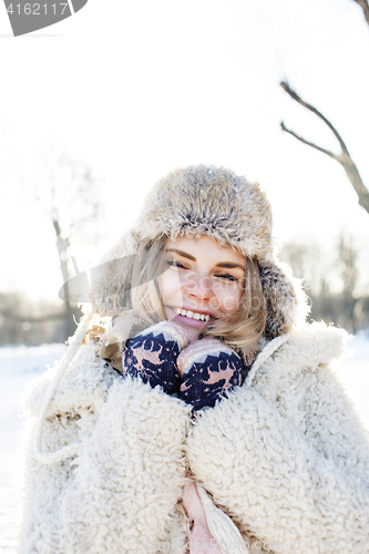 Image of young pretty teenage hipster girl outdoor in winter snow park having fun drinking coffee, warming up happy smiling, lifestyle people concept