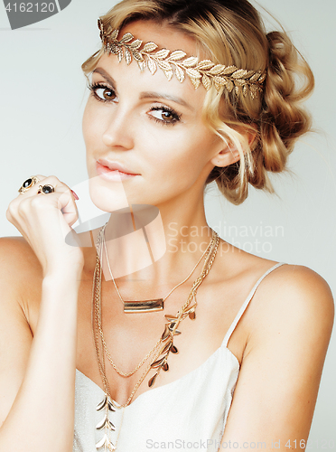 Image of young blond woman dressed like ancient greek godess, gold jewelry close up isolated
