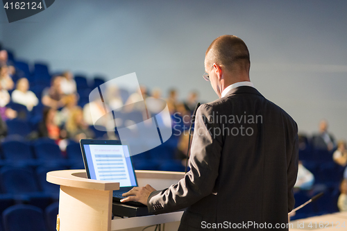 Image of Public speaker giving talk at business event.