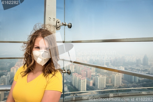 Image of Woman in medical mask against the air pollution