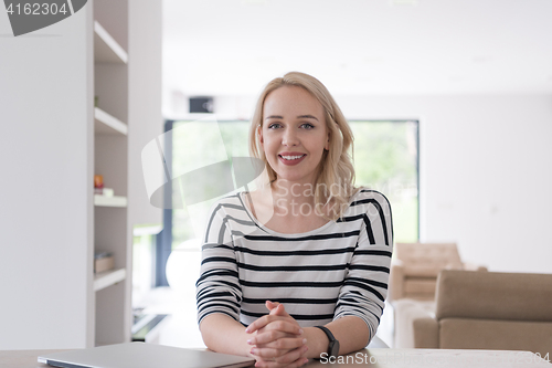 Image of Young woman with laptop at home