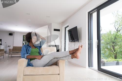 Image of african american woman at home with digital tablet