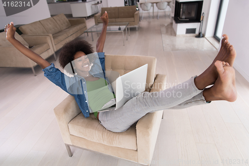 Image of African American women at home in the chair using a laptop