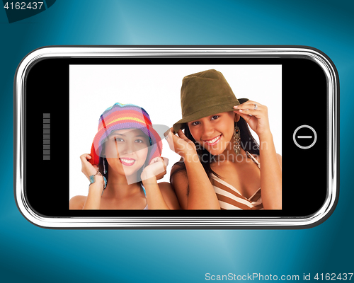 Image of Two Teenage Girls In Hats Picture On Smartphone