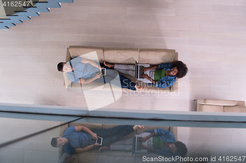 Image of young multiethnic couple relaxes in the living room top view