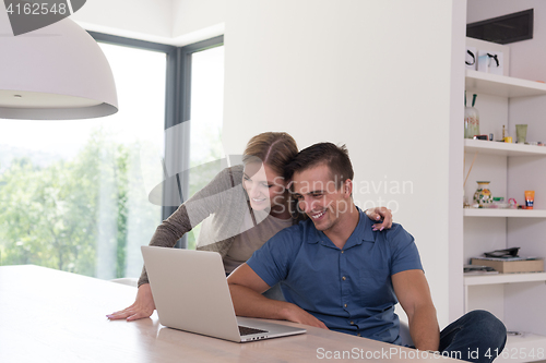 Image of couple using laptop at home