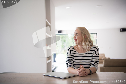 Image of Young woman with laptop at home