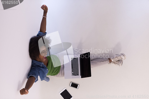 Image of african american woman sitting on floor with laptop top view