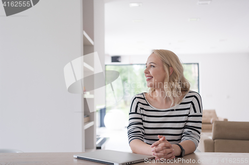 Image of Young woman with laptop at home