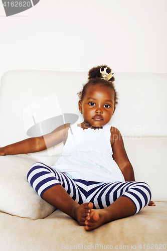 Image of little pretty african american girl sitting in white chair weari