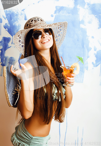 Image of cute bright woman in sunglasses and hat with cocktail in bikini 