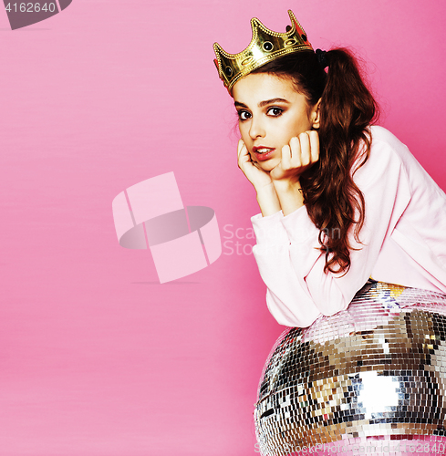 Image of young cute disco girl on pink background with disco ball and cro