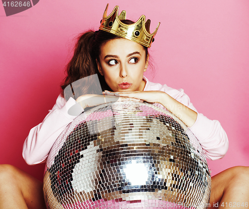 Image of young cute disco girl on pink background with disco ball and cro